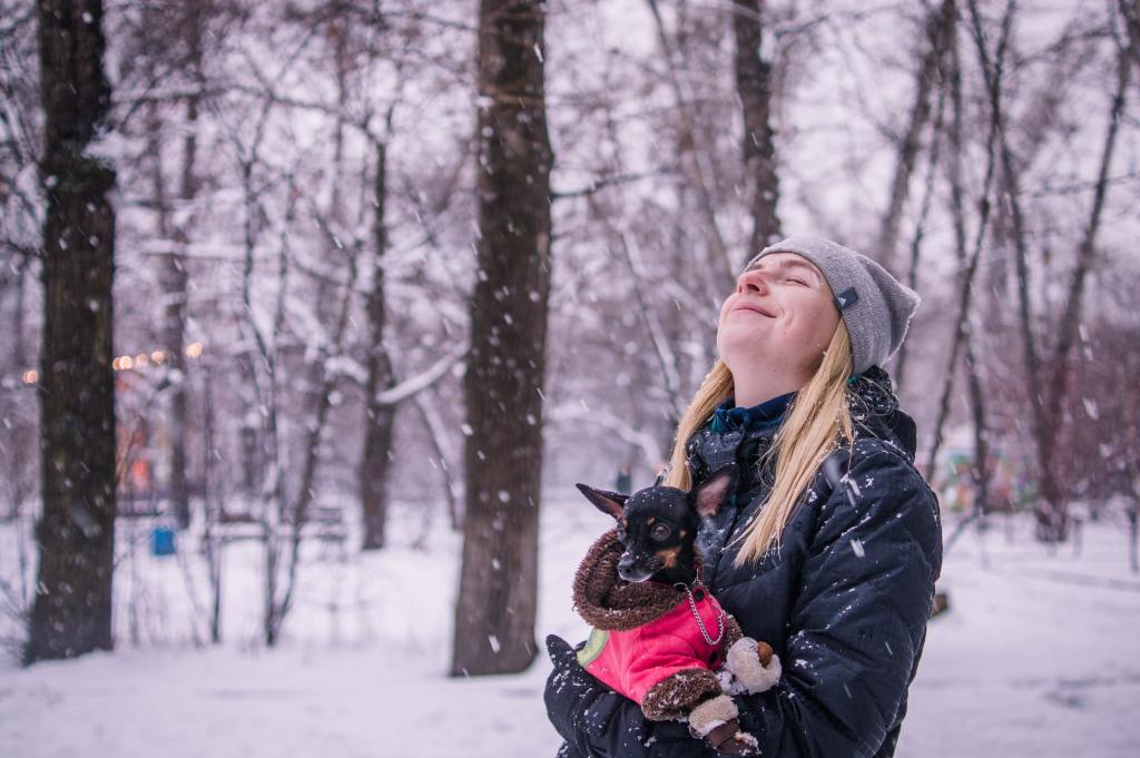 woman holding dog in snow